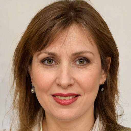 Joyful white adult female with long  brown hair and green eyes