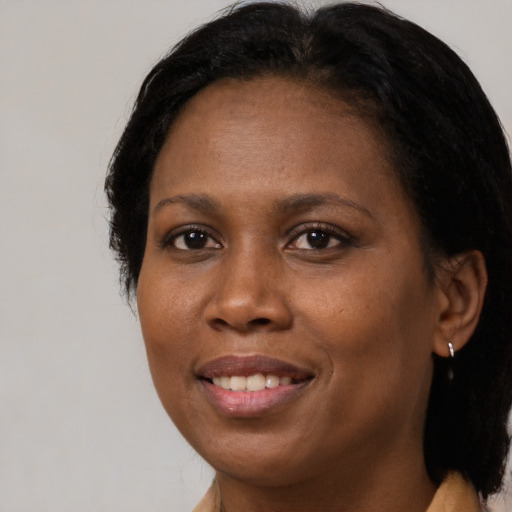 Joyful black adult female with long  brown hair and brown eyes