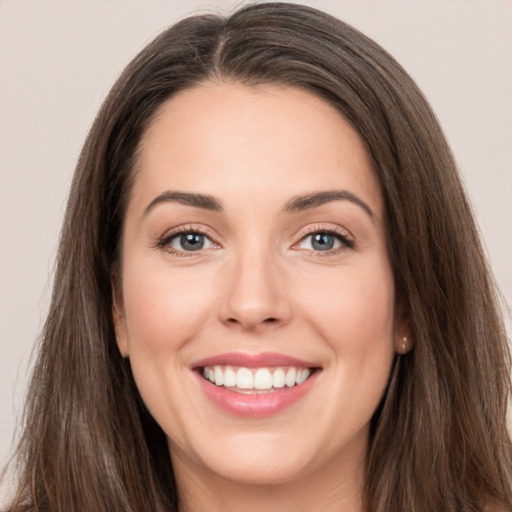 Joyful white young-adult female with long  brown hair and brown eyes