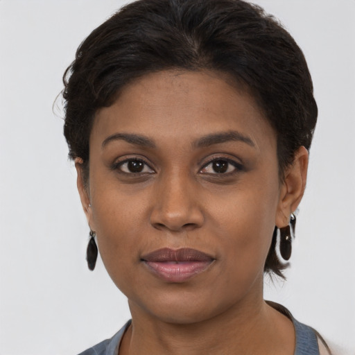 Joyful black young-adult female with short  brown hair and brown eyes