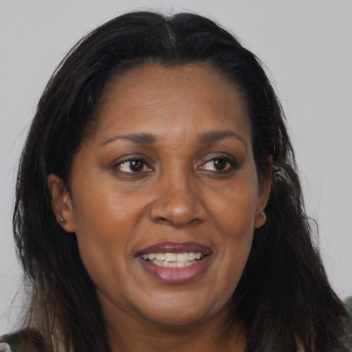 Joyful black adult female with long  brown hair and brown eyes