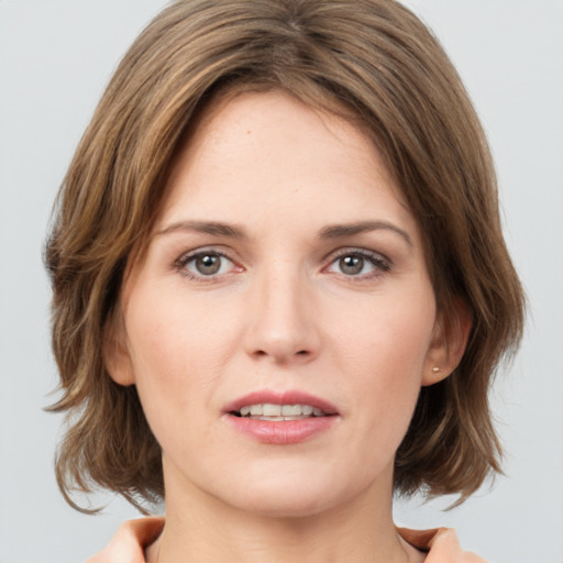 Joyful white young-adult female with medium  brown hair and green eyes