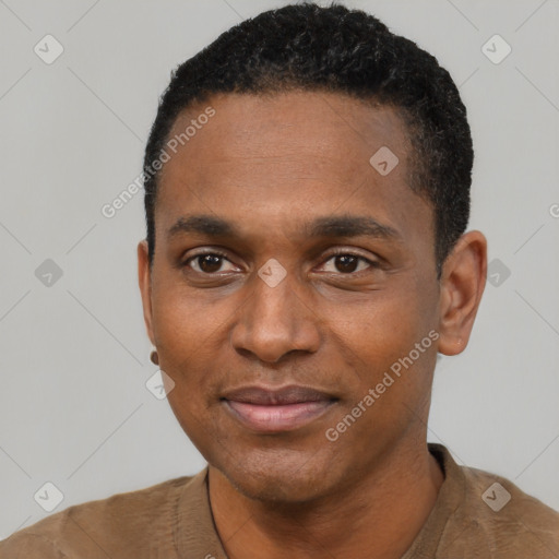 Joyful black young-adult male with short  black hair and brown eyes