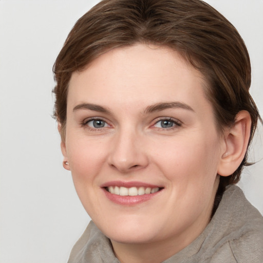 Joyful white young-adult female with short  brown hair and grey eyes