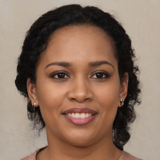 Joyful black young-adult female with long  brown hair and brown eyes