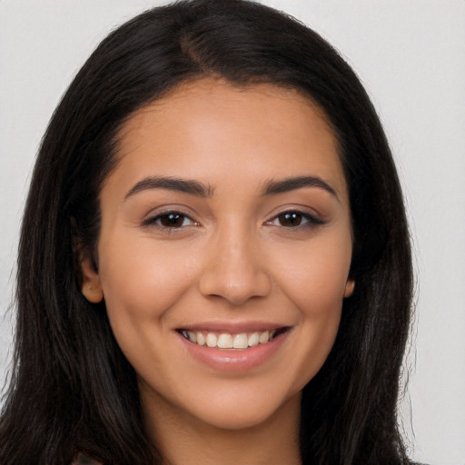 Joyful latino young-adult female with long  brown hair and brown eyes