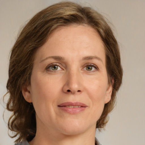 Joyful white adult female with medium  brown hair and grey eyes