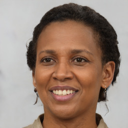 Joyful black adult female with short  brown hair and brown eyes