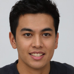 Joyful latino young-adult male with short  brown hair and brown eyes