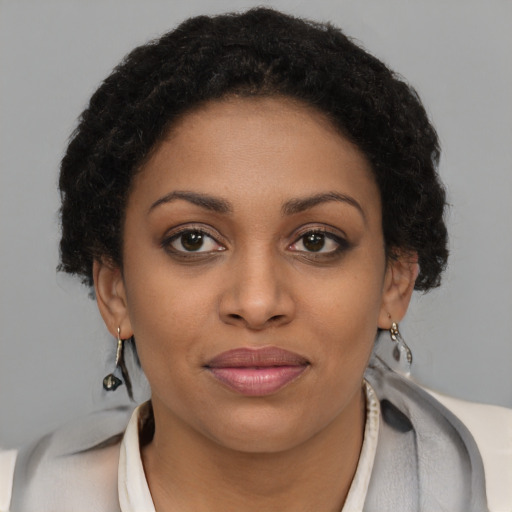 Joyful black young-adult female with short  brown hair and brown eyes