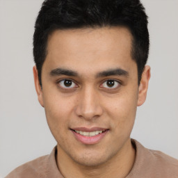 Joyful latino young-adult male with short  brown hair and brown eyes