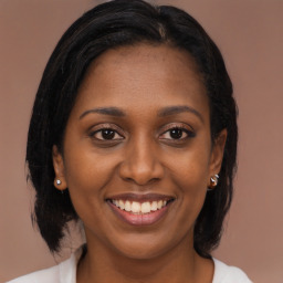 Joyful black young-adult female with long  brown hair and brown eyes