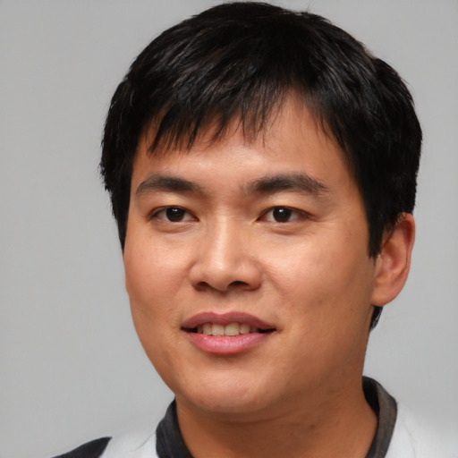 Joyful asian young-adult male with short  black hair and brown eyes