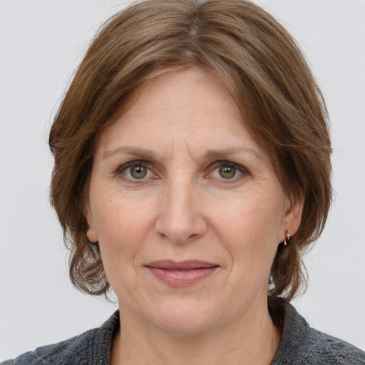 Joyful white adult female with medium  brown hair and grey eyes