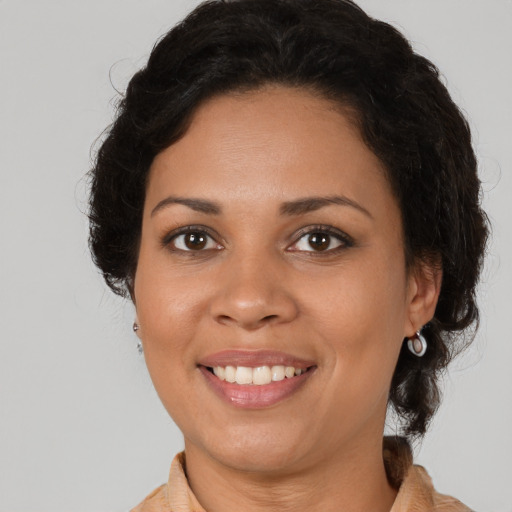 Joyful latino adult female with medium  brown hair and brown eyes