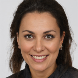 Joyful white adult female with long  brown hair and brown eyes