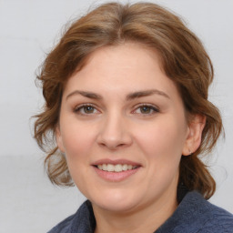 Joyful white young-adult female with medium  brown hair and blue eyes