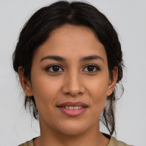 Joyful latino young-adult female with medium  brown hair and brown eyes