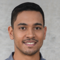 Joyful latino young-adult male with short  brown hair and brown eyes