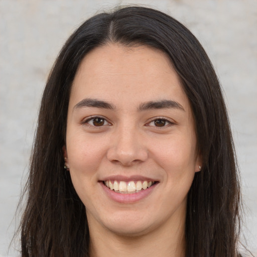 Joyful latino young-adult female with long  brown hair and brown eyes
