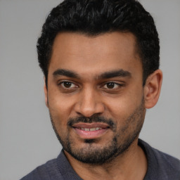 Joyful black young-adult male with short  black hair and brown eyes