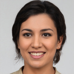 Joyful latino young-adult female with medium  brown hair and brown eyes