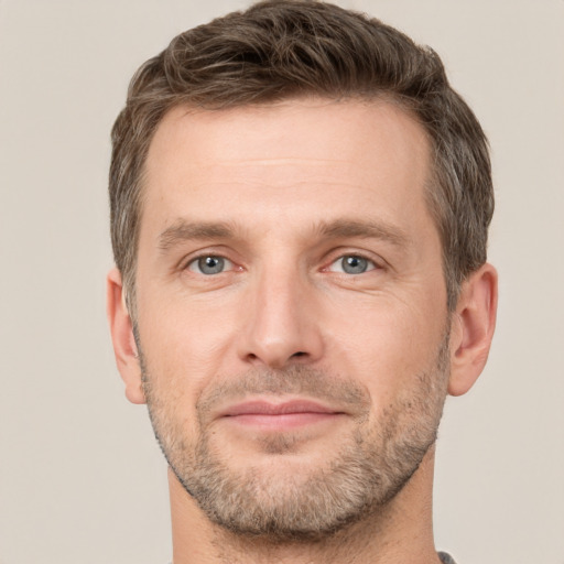 Joyful white adult male with short  brown hair and grey eyes