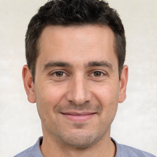 Joyful white adult male with short  brown hair and brown eyes