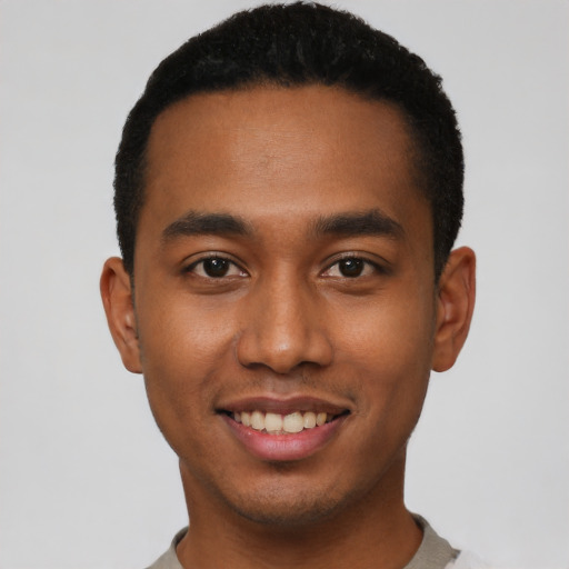 Joyful black young-adult male with short  black hair and brown eyes