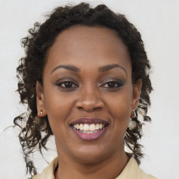 Joyful black young-adult female with long  brown hair and brown eyes