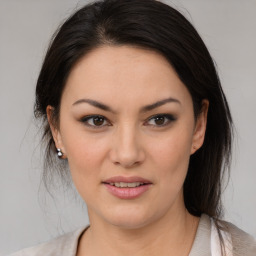 Joyful latino young-adult female with medium  brown hair and brown eyes