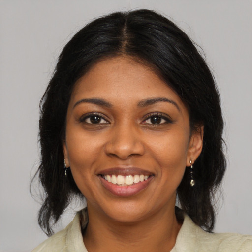 Joyful black young-adult female with medium  brown hair and brown eyes