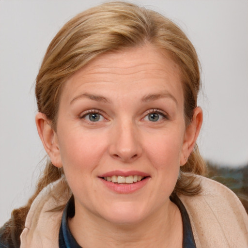 Joyful white adult female with medium  brown hair and blue eyes