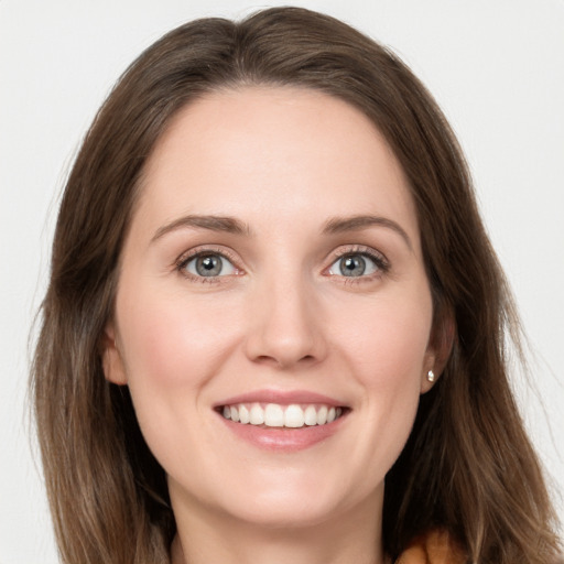 Joyful white young-adult female with long  brown hair and grey eyes