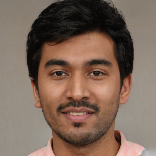 Joyful latino young-adult male with short  black hair and brown eyes
