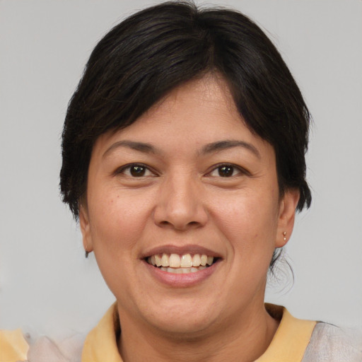 Joyful asian adult female with medium  brown hair and brown eyes