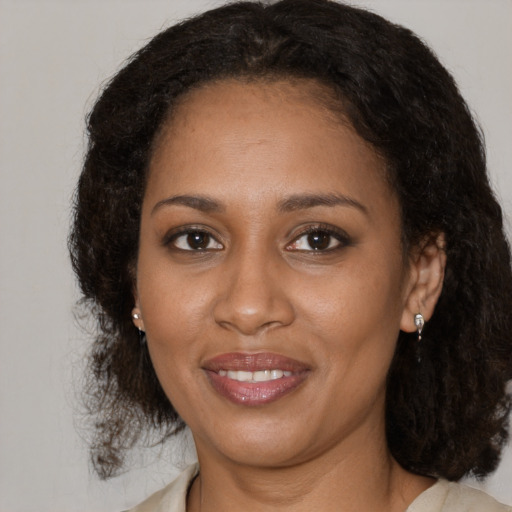Joyful black young-adult female with medium  brown hair and brown eyes