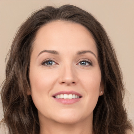 Joyful white young-adult female with long  brown hair and green eyes