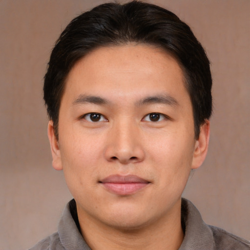 Joyful asian young-adult male with short  brown hair and brown eyes