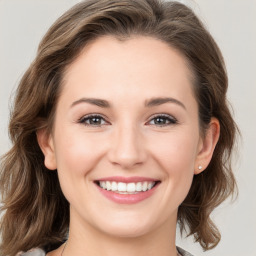 Joyful white young-adult female with medium  brown hair and grey eyes