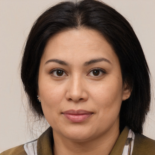 Joyful latino adult female with medium  brown hair and brown eyes