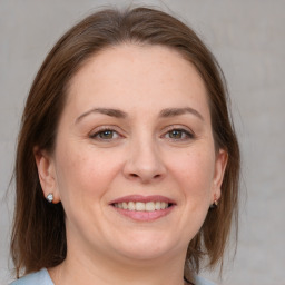 Joyful white adult female with medium  brown hair and grey eyes