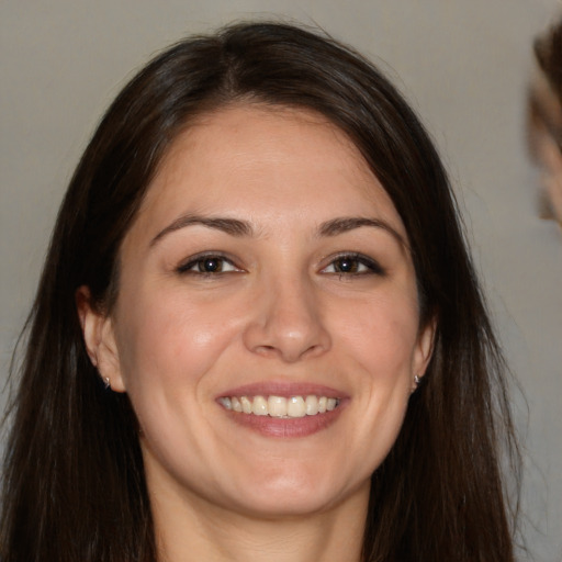 Joyful white young-adult female with long  brown hair and brown eyes