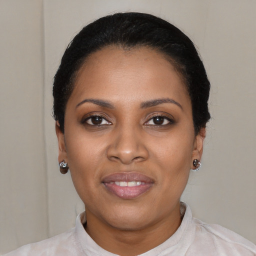 Joyful black young-adult female with short  black hair and brown eyes