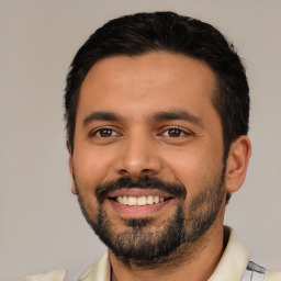 Joyful latino young-adult male with short  black hair and brown eyes