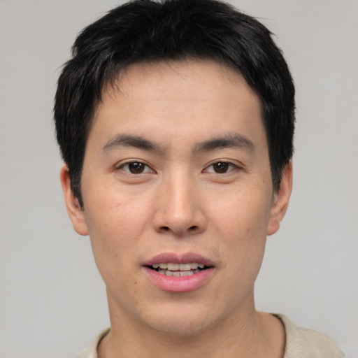 Joyful asian young-adult male with short  brown hair and brown eyes
