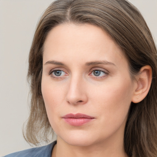 Joyful white young-adult female with long  brown hair and blue eyes