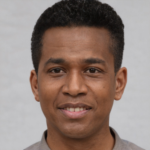 Joyful black young-adult male with short  black hair and brown eyes