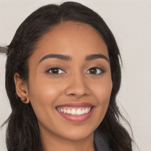 Joyful latino young-adult female with long  brown hair and brown eyes