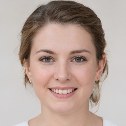 Joyful white young-adult female with medium  brown hair and green eyes